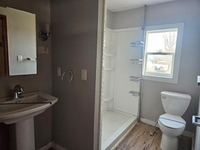 bathroom featuring sink, toilet, hardwood / wood-style floors, and a shower