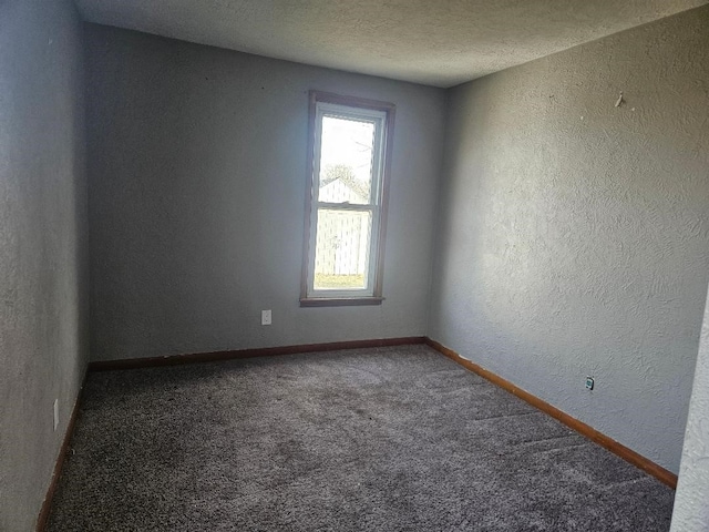 carpeted spare room featuring a textured ceiling