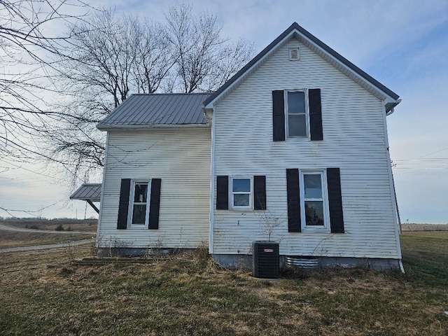 rear view of property with a yard and central air condition unit