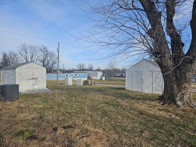 view of yard with a water view, a storage unit, and central AC unit