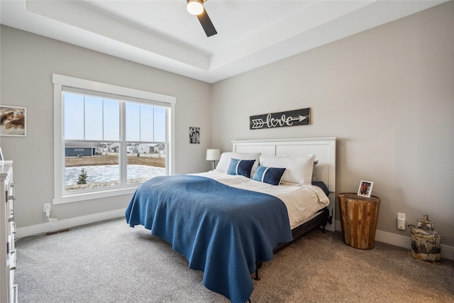 bedroom featuring carpet flooring, ceiling fan, and a tray ceiling