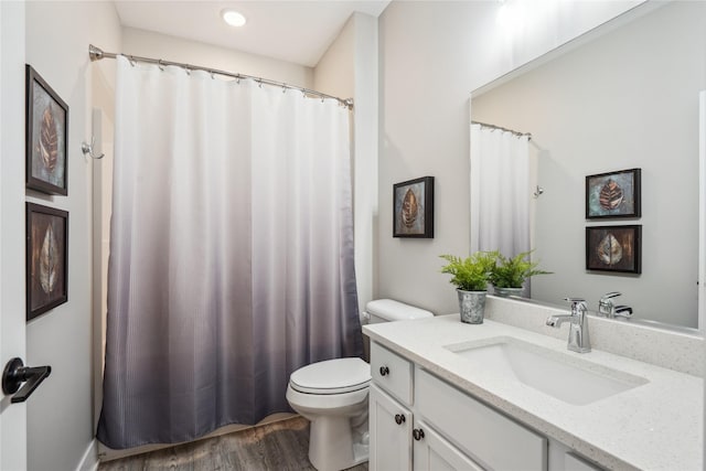 bathroom featuring wood-type flooring, vanity, and toilet