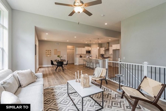 living room with light hardwood / wood-style flooring and ceiling fan