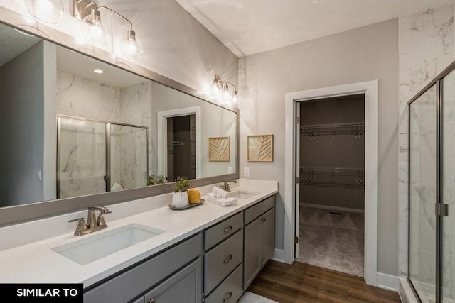 bathroom with a shower with door, vanity, and hardwood / wood-style floors