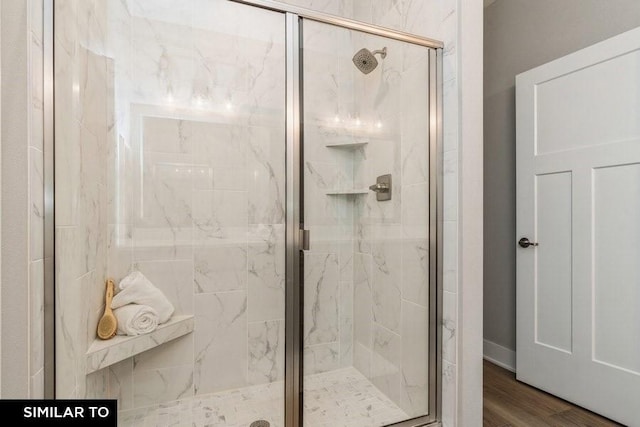 bathroom featuring a shower with door and wood-type flooring