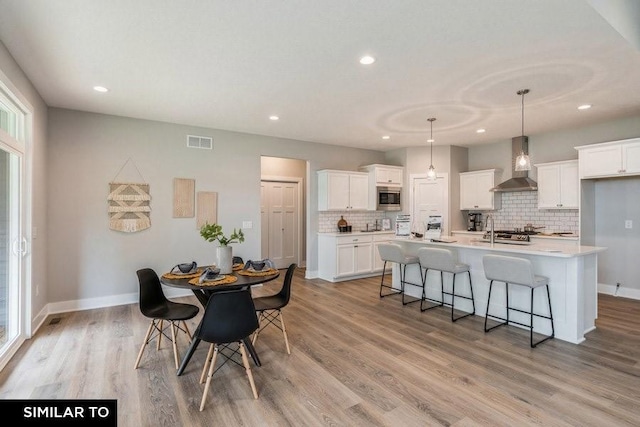 dining space with sink and light hardwood / wood-style floors