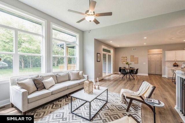 living room with ceiling fan, light hardwood / wood-style flooring, and a wealth of natural light