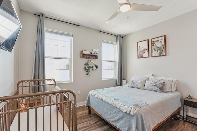 bedroom with multiple windows, dark hardwood / wood-style floors, and ceiling fan