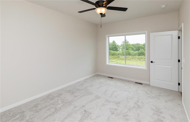 unfurnished room with light colored carpet and ceiling fan