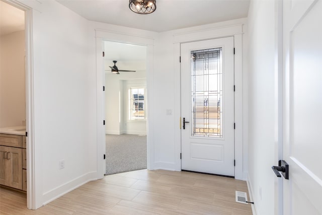 carpeted foyer with ceiling fan