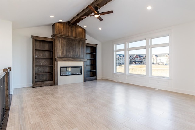 unfurnished living room with ceiling fan, a fireplace, and vaulted ceiling with beams