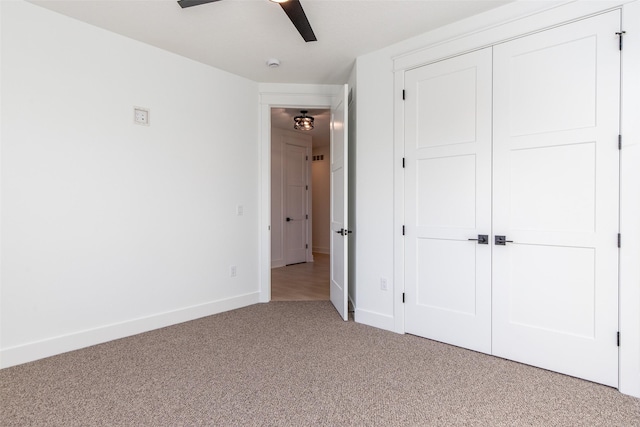 unfurnished bedroom featuring ceiling fan, a closet, and light carpet