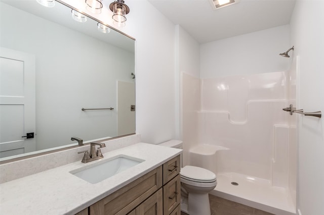 bathroom featuring vanity, a shower, and toilet