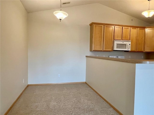 kitchen featuring vaulted ceiling, light carpet, and decorative light fixtures