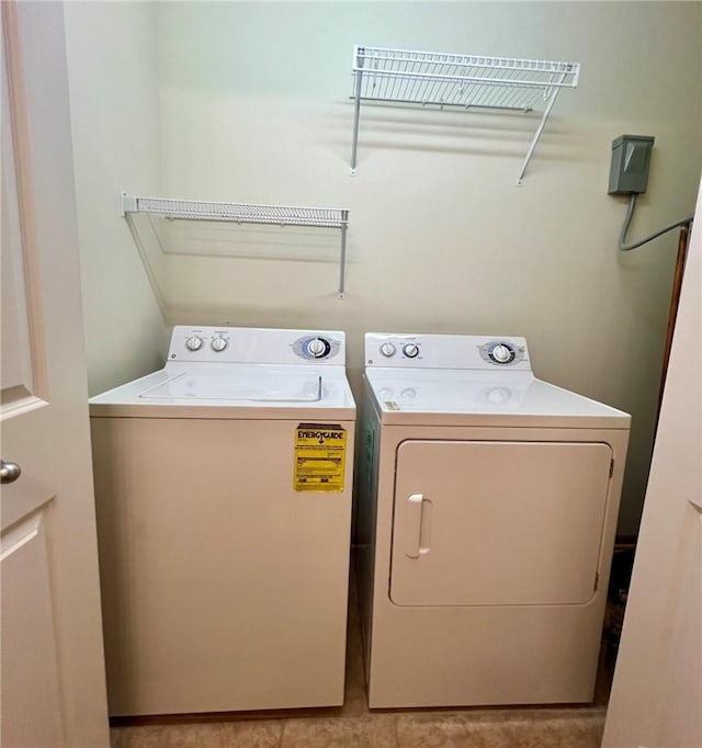 clothes washing area featuring light tile patterned flooring and washing machine and clothes dryer