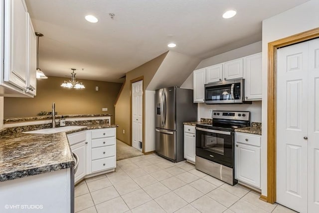 kitchen with light tile patterned flooring, sink, white cabinets, hanging light fixtures, and stainless steel appliances