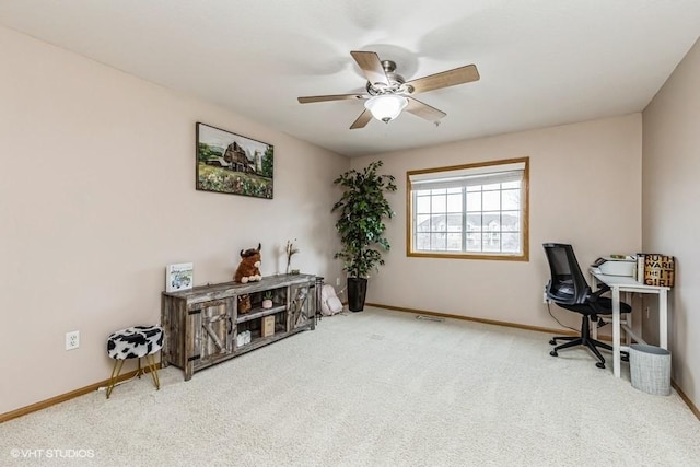 carpeted office space featuring ceiling fan