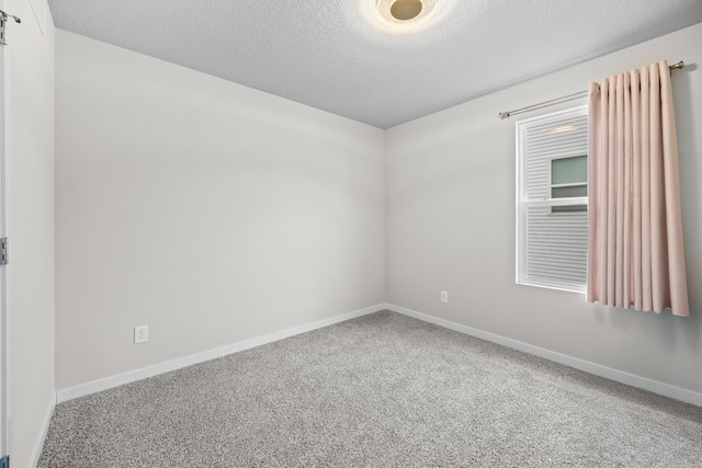 carpeted empty room with a textured ceiling