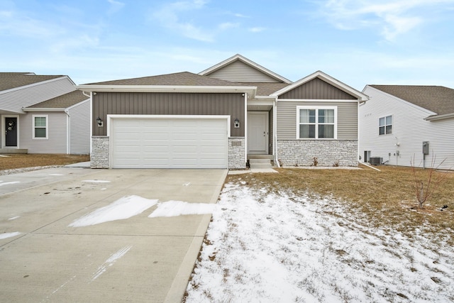 view of front of property featuring a garage and central air condition unit