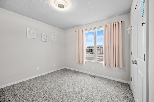 spare room with carpet flooring and a textured ceiling