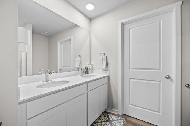 bathroom featuring vanity, hardwood / wood-style floors, and a textured ceiling