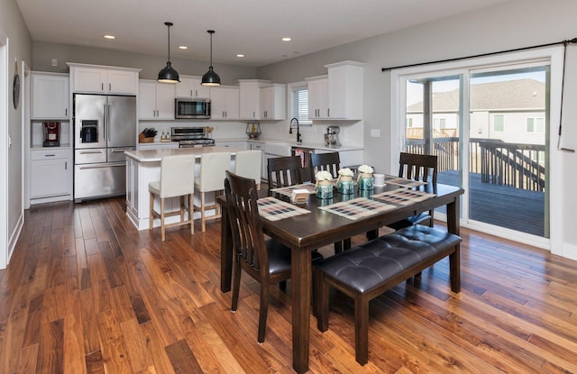 dining room featuring sink and dark hardwood / wood-style flooring