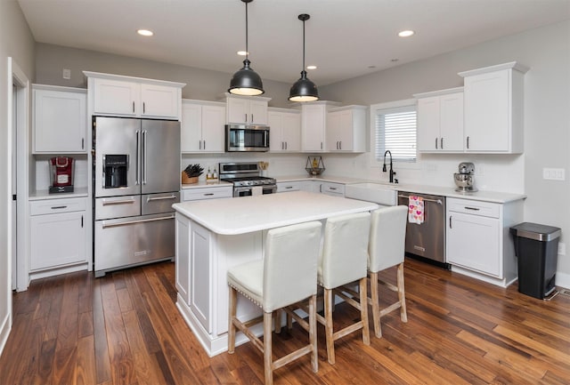 kitchen featuring sink, stainless steel appliances, white cabinets, a kitchen island, and decorative backsplash