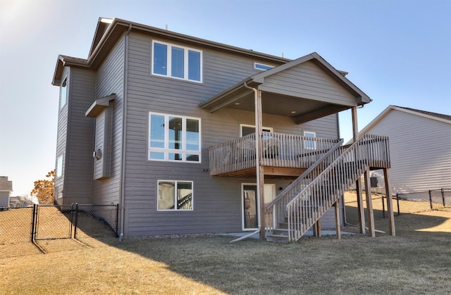 back of property with a wooden deck and a yard