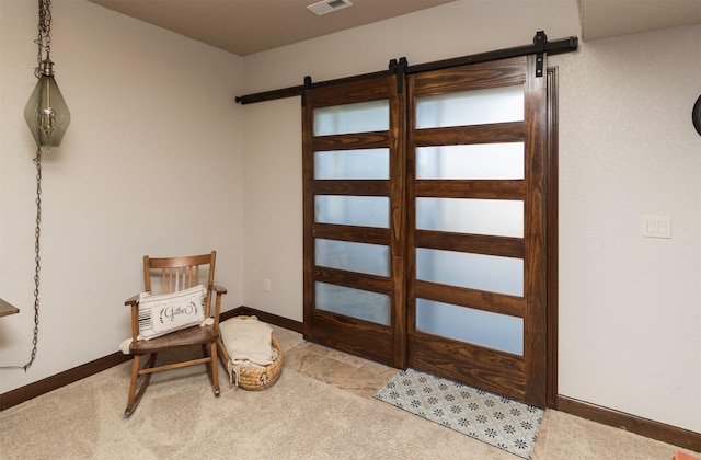 sitting room with light colored carpet and a barn door