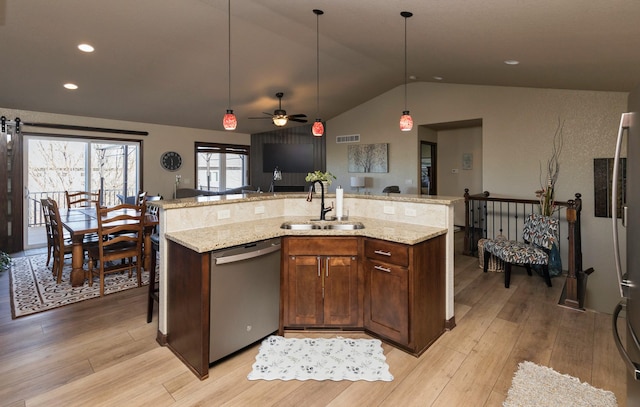 kitchen featuring sink, a center island with sink, decorative light fixtures, vaulted ceiling, and stainless steel dishwasher