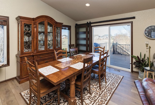 dining room featuring lofted ceiling and light wood-type flooring