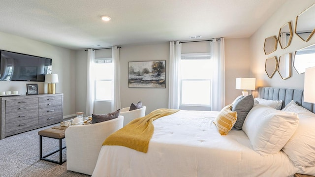 bedroom featuring light carpet and a textured ceiling