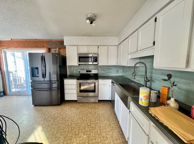 kitchen with sink, appliances with stainless steel finishes, tasteful backsplash, a textured ceiling, and white cabinets