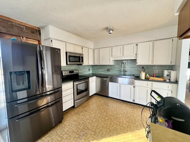 kitchen with stainless steel appliances, white cabinetry, and sink