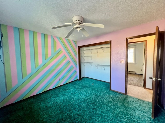 unfurnished bedroom with a baseboard heating unit, dark carpet, ceiling fan, a textured ceiling, and a closet