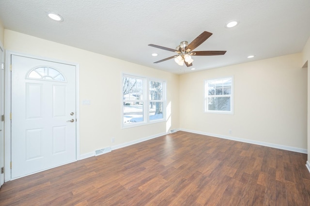 foyer entrance with dark hardwood / wood-style flooring, ceiling fan, and a textured ceiling