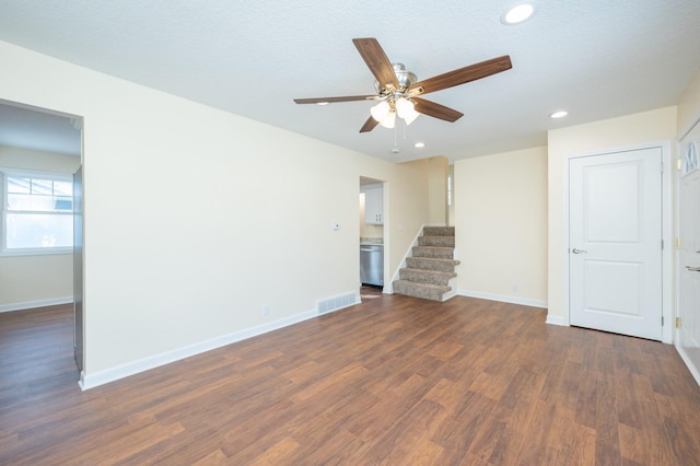 unfurnished living room with ceiling fan, dark wood-type flooring, and a textured ceiling