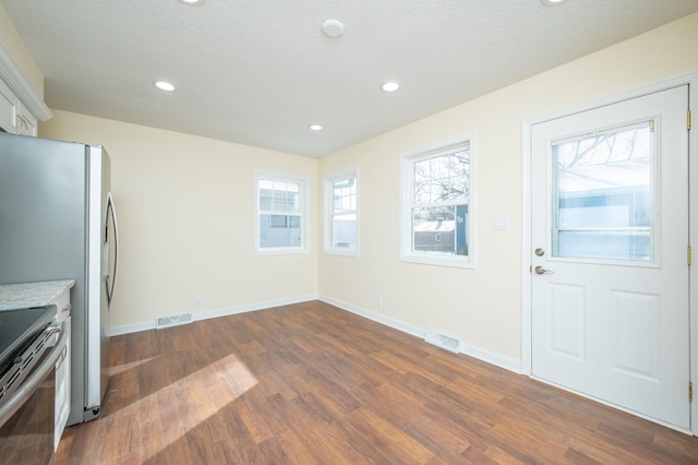 entryway featuring a healthy amount of sunlight, dark hardwood / wood-style floors, and a textured ceiling