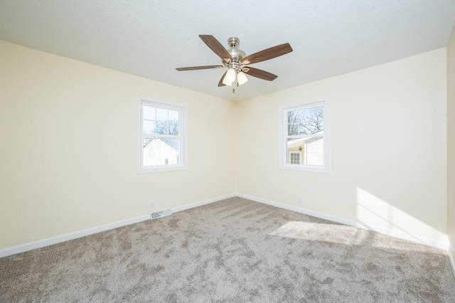 carpeted spare room featuring ceiling fan