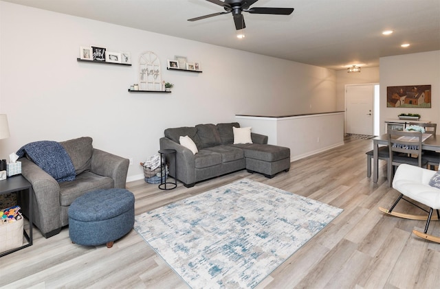 living room with ceiling fan and light wood-type flooring