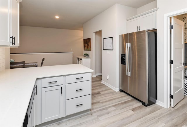 kitchen with white cabinetry, stainless steel refrigerator with ice dispenser, kitchen peninsula, and light hardwood / wood-style flooring