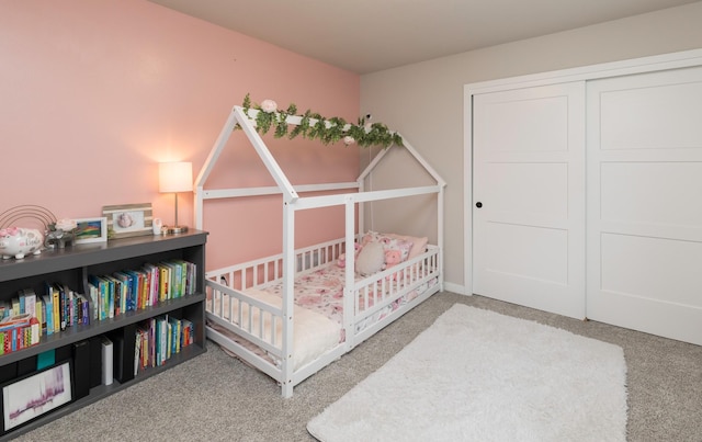 carpeted bedroom with a closet and a crib