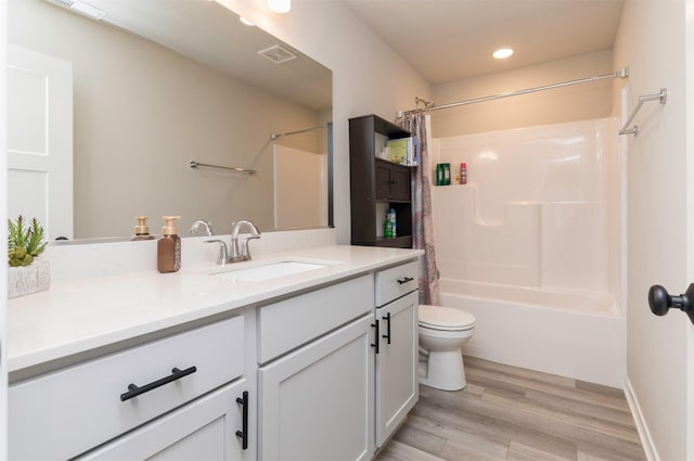 full bathroom featuring vanity, wood-type flooring, shower / bath combination with curtain, and toilet