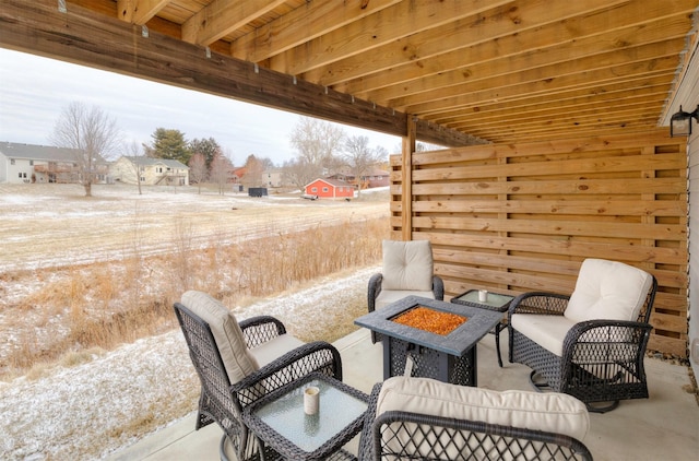 snow covered patio featuring an outdoor fire pit