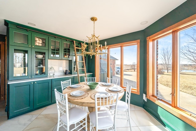 dining space featuring baseboards and a notable chandelier