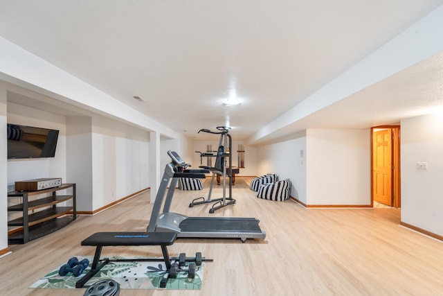 workout room featuring baseboards and wood finished floors