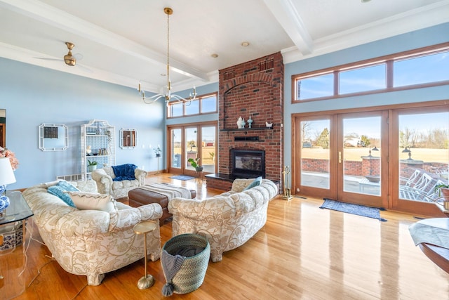 living area featuring an AC wall unit, french doors, beam ceiling, and wood finished floors