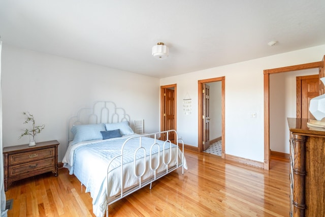 bedroom with light wood-style flooring and baseboards