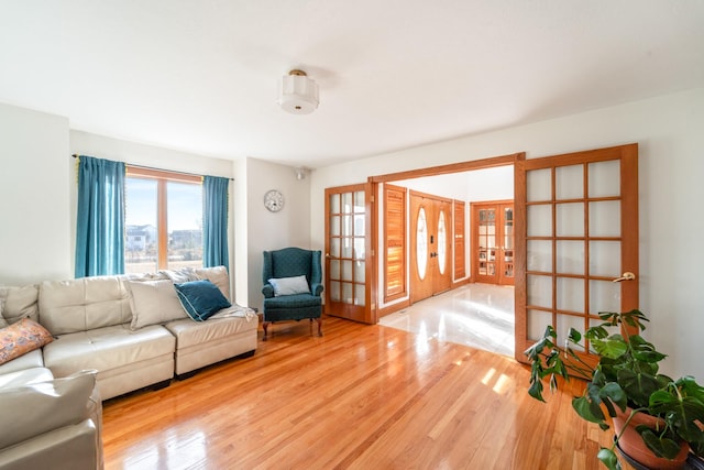 living area featuring light wood-type flooring and french doors