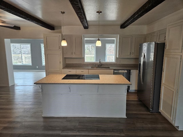 kitchen with appliances with stainless steel finishes, decorative light fixtures, sink, dark hardwood / wood-style flooring, and a center island